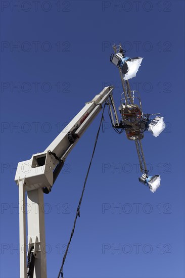 Three spotlights in front of a blue sky