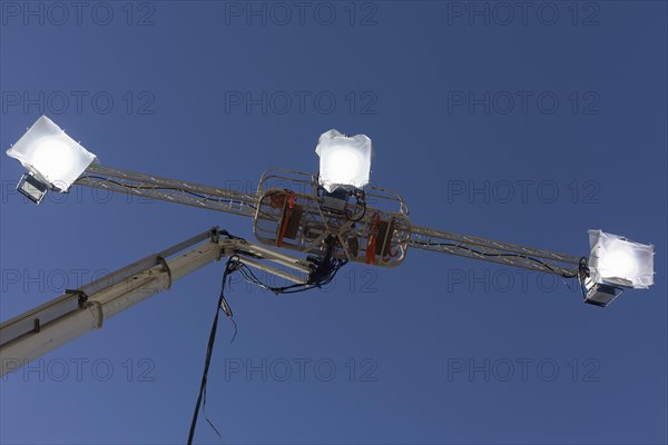 Three spotlights in front of a blue sky