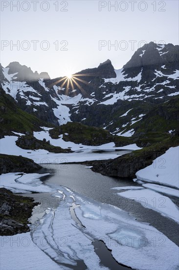 Sun over lake Isvatnet with ice