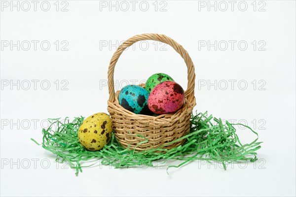 Coloured quail eggs in baskets