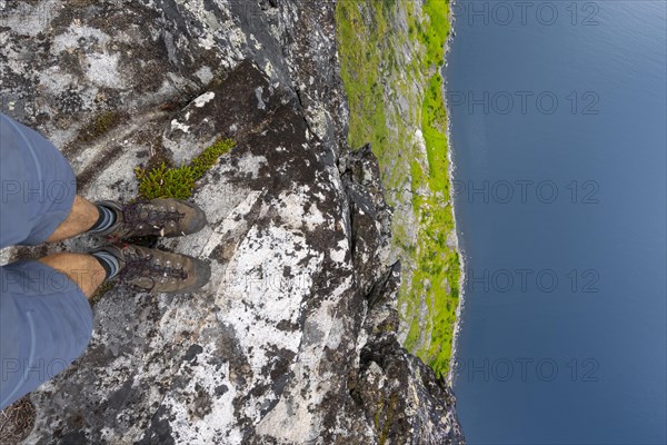 Hiker standing on steep cliff