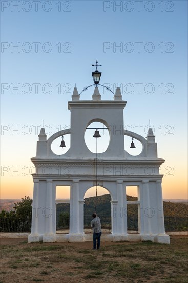 Bell ringer ringing the bells at the bell tower of the chapel Ermita Reina de los Angeles