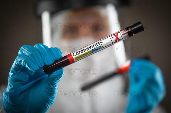 Female Doctor or Nurse Holding Test Tube of Blood Labeled Positive for Coronavirus COVID-19 Disease