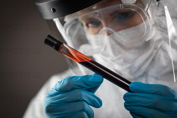 Female Lab Worker Holds Test Tube of Blood For Testing