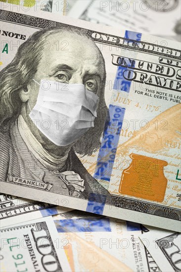 One hundred dollar bill with medical face mask on face of benjamin franklin