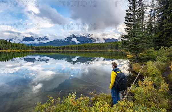 Hiker at the lakeside looking at mountains