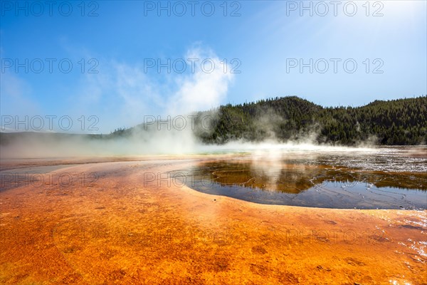 Steaming hot spring with colored mineral deposits