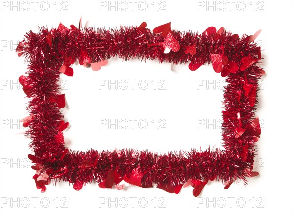 Red tinsel with hearts border frame shape on a white background ready for your own message