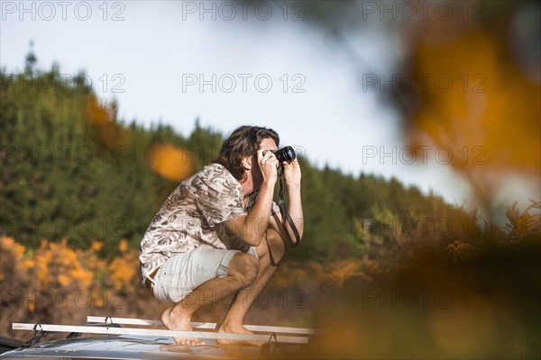 Guy with camera on car roof