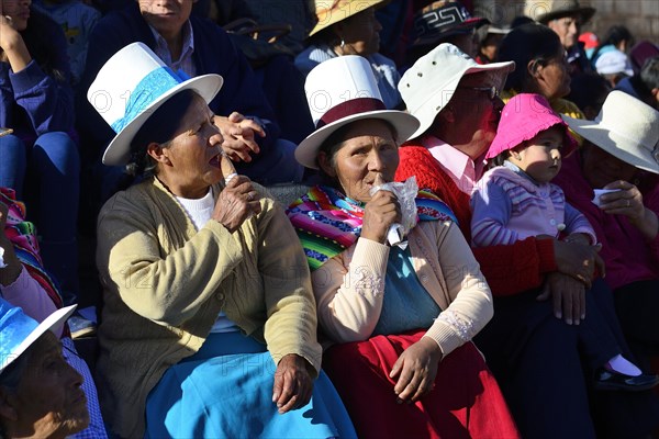 Two indigenous woman lapping up ice cream at the parade on the eve of Inti Raymi