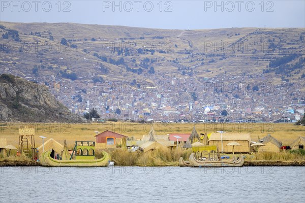 Floating island of the Uro with the city of Puno in the background