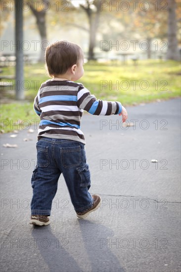 Happy young baby boy walking in the park