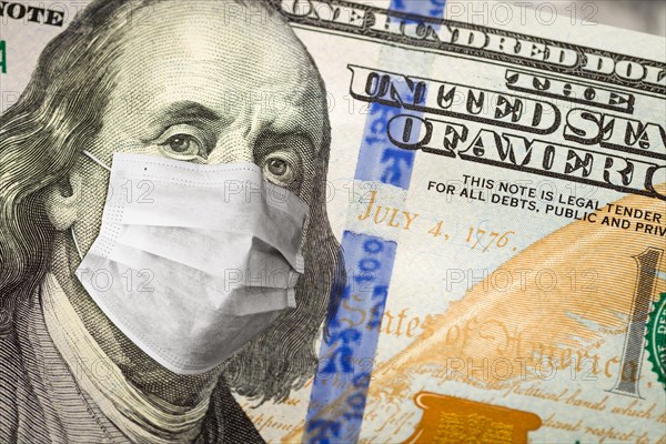 One hundred dollar bill with medical face mask on face of benjamin franklin