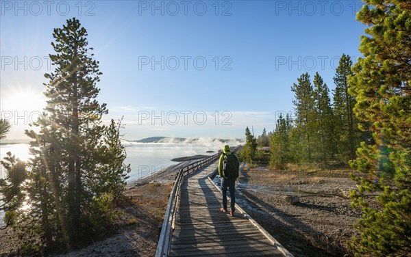 Hiker on boardwalk on the shore of the West Thumb of Yellowstone Lake