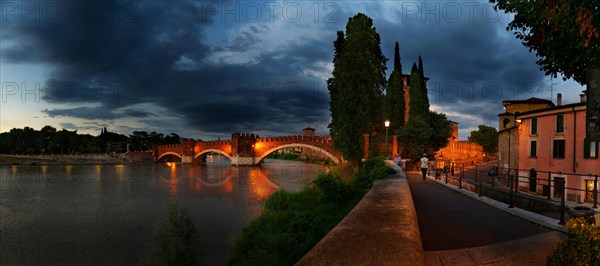 River Adige with the stone bridge Ponte Scaligero at sunset