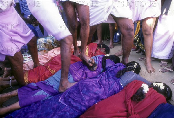 Poojari or priest walking on women in Mahasivaratri festival at poochiyur near Coimbatore