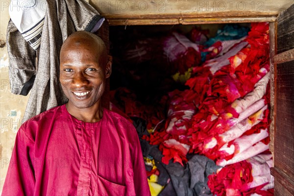 Shopkeeper before his shop full of colourful leather