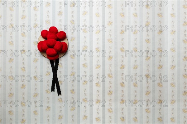 Original Black Forest Bollen hat in front of old-fashioned wallpaper wall