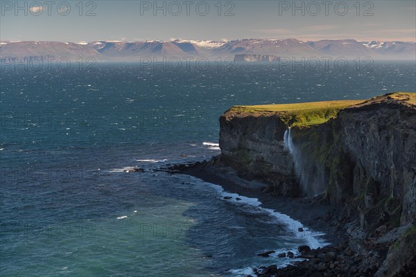 Waterfall falls over cliff and is blown away by wind