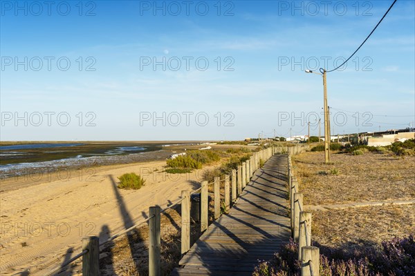 Wooden walkways with view on wetlands of Ria Formosa on Faro Beach Peninsula