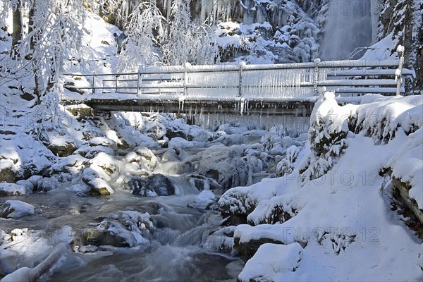 Bridge with icicles and frozen stream