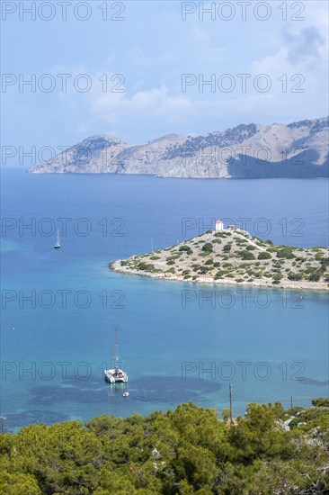 View of sailing boats and old windmill in Panormitis Bay