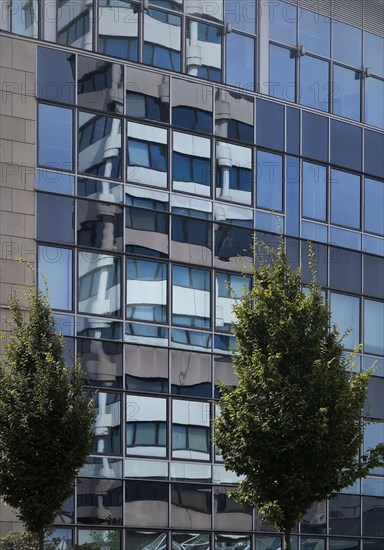 Savings bank tower reflected in the glass facade of GESCO AG