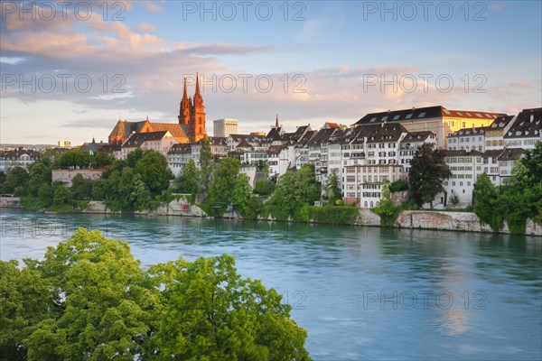 View of the Basel Cathedral in the middle of the old town of Basel with the turquoise Rhine River in the foreground