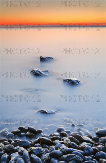 View from Arbon over Lake Constance at sunrise with stones in the foreground