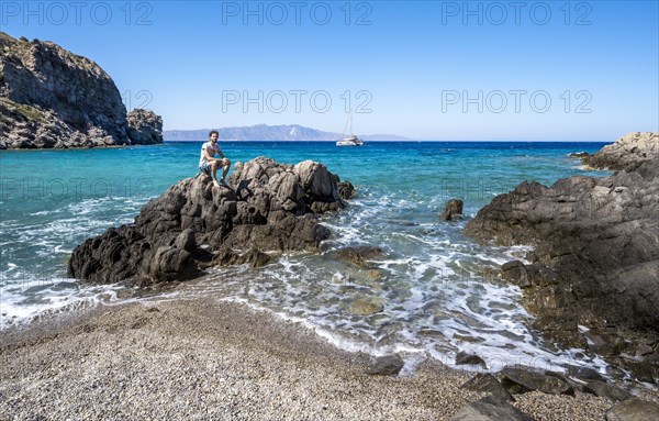Young man sitting on a rock