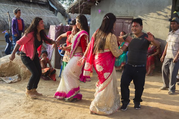 People of the Tharu ethnic group dance and laugh during a wedding