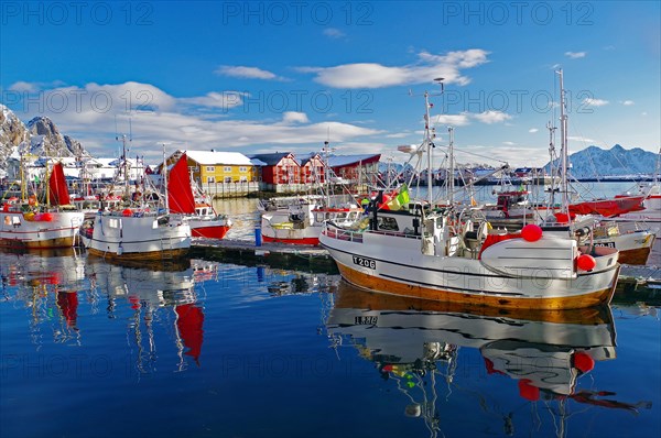 Fishing boats with red sails reflected in the water