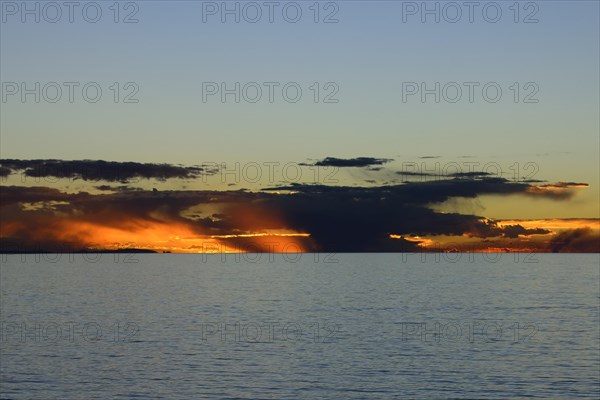 Glowing sky with clouds over the lake at sunset