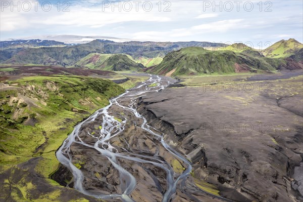 River with fanned out branches through black lava sand