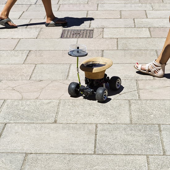 Hat on wheels collects money from passers-by for buskers