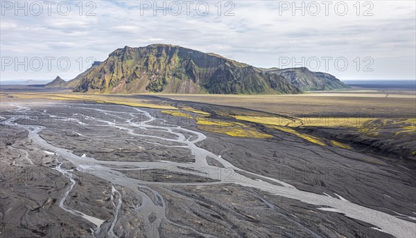 River with fanned out branches through black lava sand