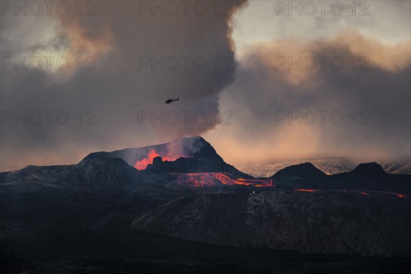 Helicopter flying over nus erupting volcano with lava fountains and lava field