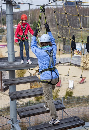 Sporty woman with her niece doing fitness climbing in the outdoor park