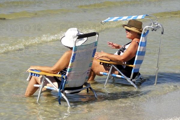 Tourists on sun lounger relaxing in the water