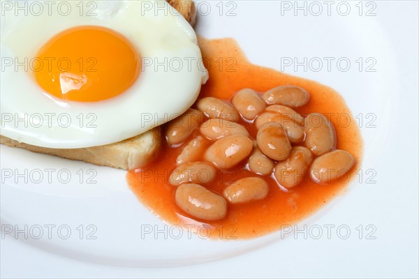 White beans with tomato sauce and fried egg on toast