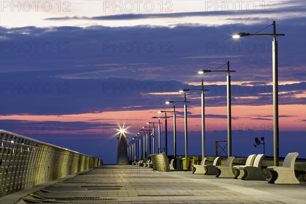 Sunrise with lighthouse at the harbour pier in Porto Maurizio