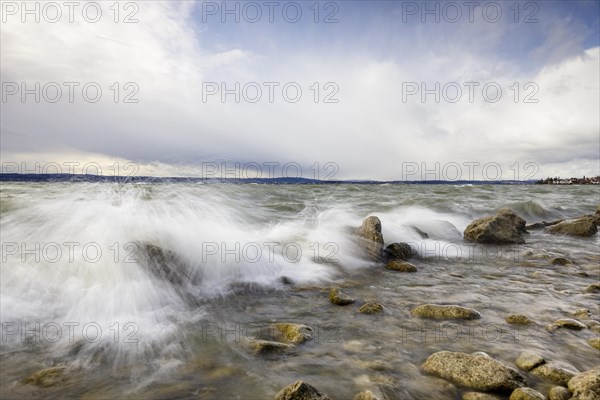 Storm Lolita raging on the rocky shore with waves in Hagnau