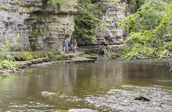 Hiker in front of shell limestone wall in the Wutach Gorge