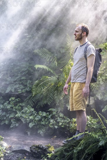 Young man standing in fog