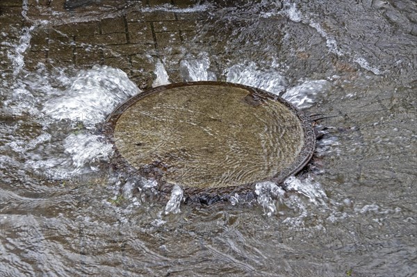 Water pouring out of a manhole cover