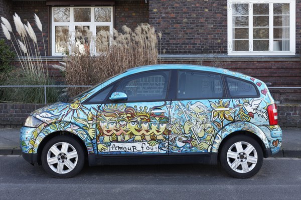Artistically painted Audi A2 parked in front of residential building