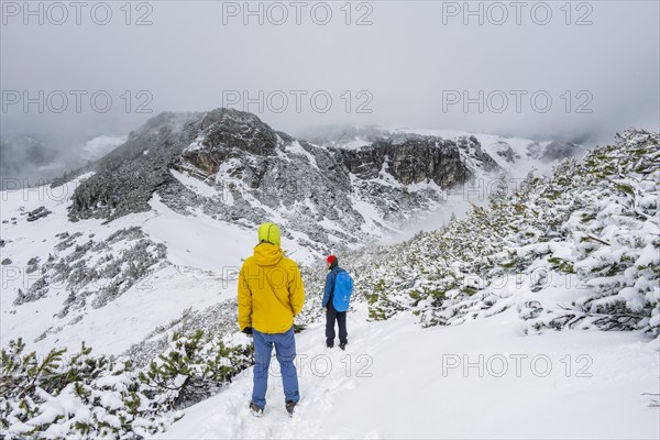 Two hikers on a hiking trail in the snow