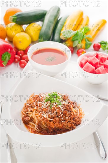 Italian classic spaghetti with bolognese sauce and fresh vegetables on background