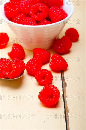 Bunch of fresh raspberry on a bowl and white wood rustic table