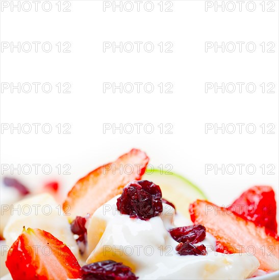 Fruit and yogurt salad healthy breakfast over white wood table